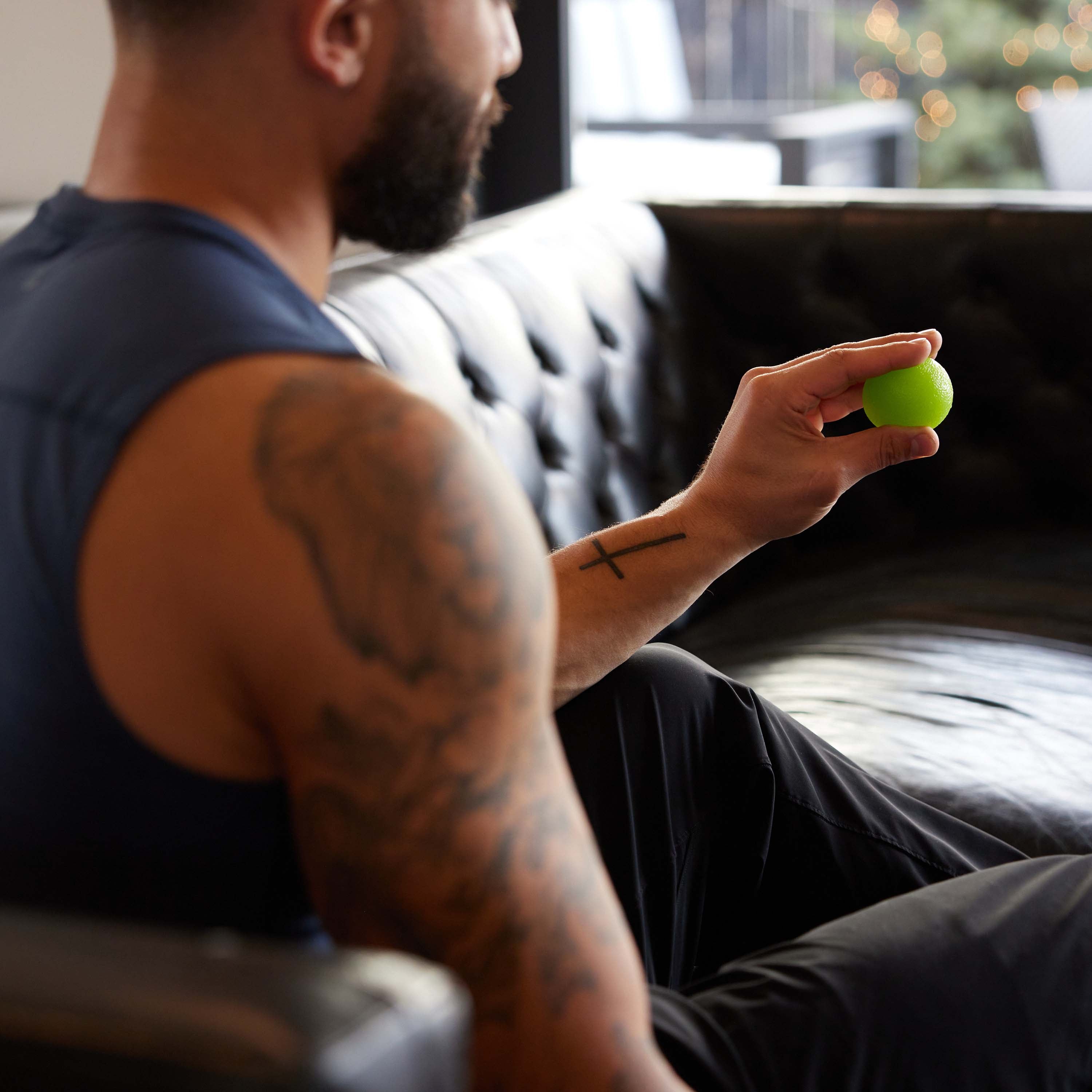 Person holding the light Green ball of the Restore Hand Therapy Kit 